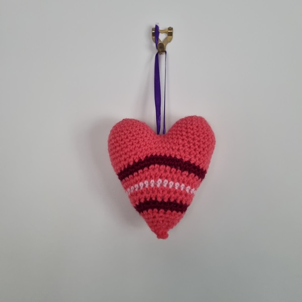 pink and red crochet heart hanging by ribbon
